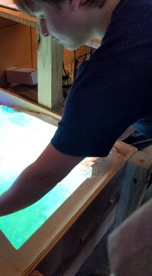 High school student using AR sand box they just built